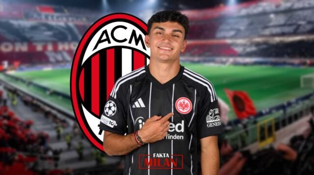Pemain muda AC Milan di stadion dengan logo klub di latar belakang.
